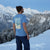 ANKERLIFT Backprint Shirt "Bluebird" am Model vor winterlicher Bergkulisse.