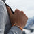 Orangefarbenes ANKERLIFT Armband vor winterlicher Bergkulisse am Handgelenk getragen